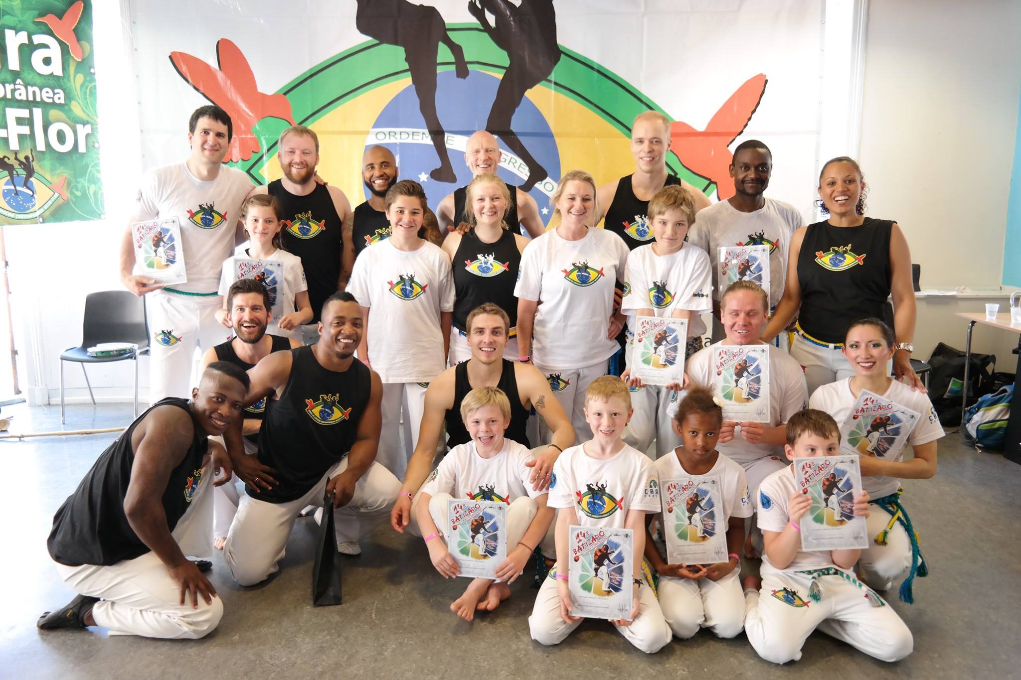 Image of a group of members of sentrum capoeria klubb sitting on the floor smiling